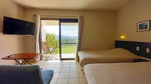 A hotel room with a bed, a TV, a desk, and a chair. - Terrace Iriomote Condominium <iriomotejima> (Taketomi)