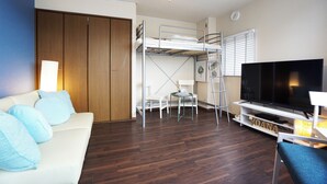 A room with a bunk bed, a TV, a sofa, and a desk. - Izu no Ie Moana (Ito)