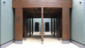 Un couloir avec une colonne centrale, qui mène à plusieurs portes de part et d’autre.