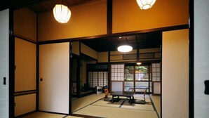 Een traditionele Japanse kamer met tatami vloerbedekking, glijdende deuren en een lage tafel met kussens.