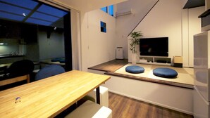 A modern kitchen with a dining area, a flat-screen TV, and a plant. - Co-ya-do Nasu (Nasu)