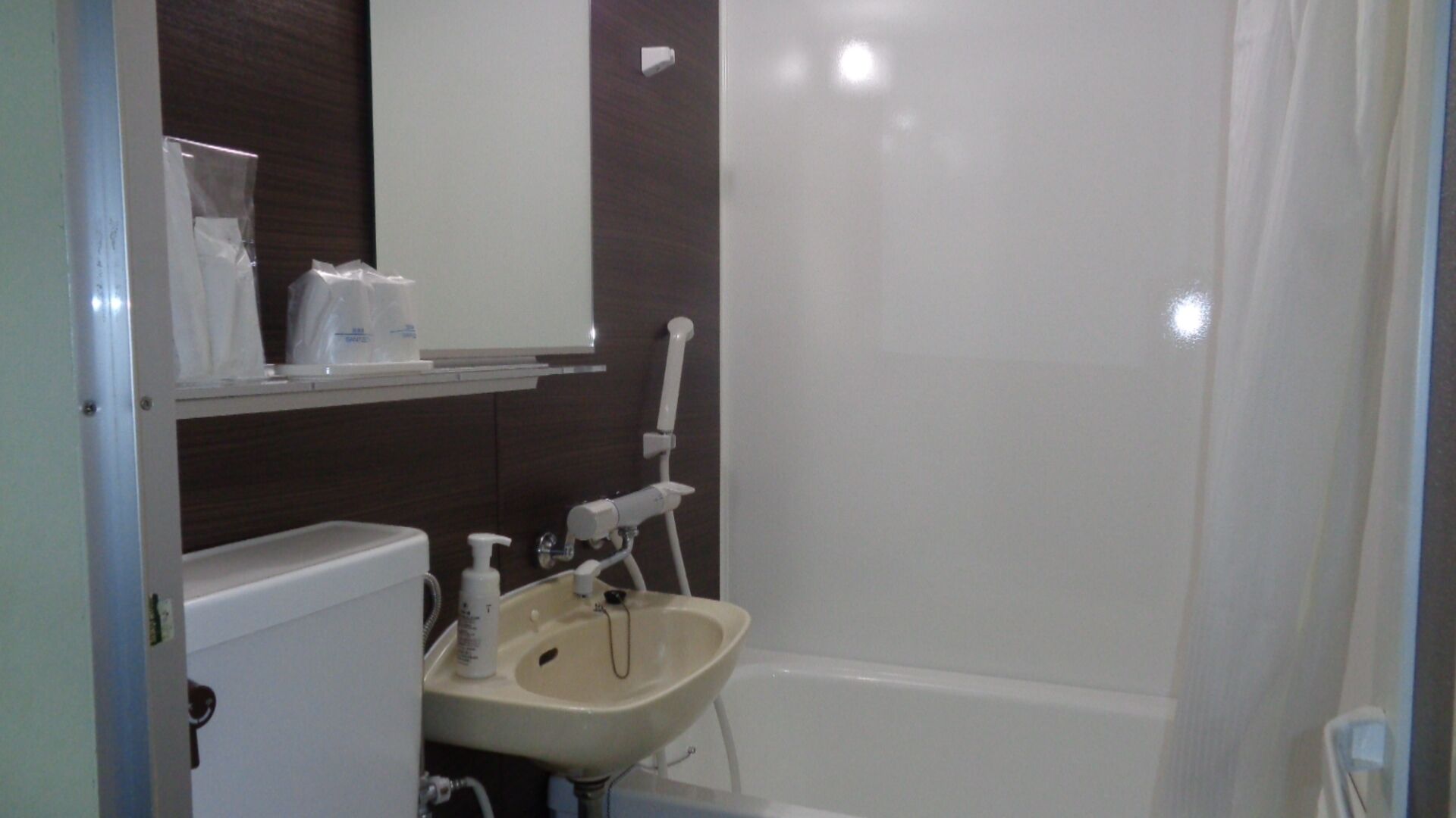 Une salle de bain avec un lavabo, un miroir et une douche.