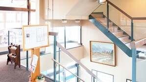 A multi-level interior with a staircase, a bulletin board, and a framed landscape painting. - Kuki City Hotel (Kuki)