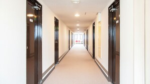 A long, narrow hallway with doors on both sides, leading to rooms. - Kuki City Hotel (Kuki)