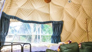 A tent with a bed, green cushions, and a metal gate. - Rupo no Mori (Fukui)