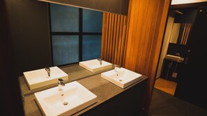 A modern bathroom with three white sinks, a large mirror, and a window with blinds. - Takiyoshi Guesthouse (Tanabe)