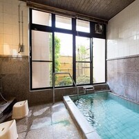 Una piscina con vistas a una cerca de madera y vegetación.