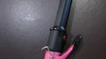 A pink and black object with a cylindrical shape and a black handle.