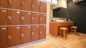 A row of wooden lockers with numbered doors, a small bar area with stools, and a mirror above the counter. - Business Hotel Wayokan/annex Wako (Inazawa)