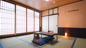 A traditional Japanese room with tatami flooring, a low table, and a cushioned bench. - Business Hotel Wayokan/annex Wako (Inazawa)