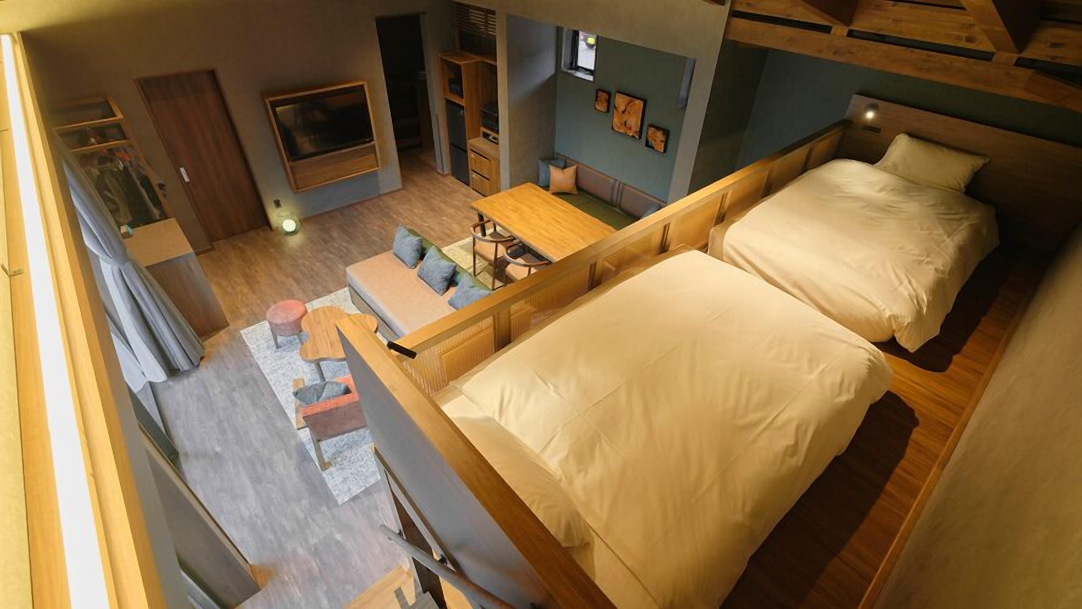 Un dormitorio tipo loft con una cama grande, un escritorio y una zona de estar.