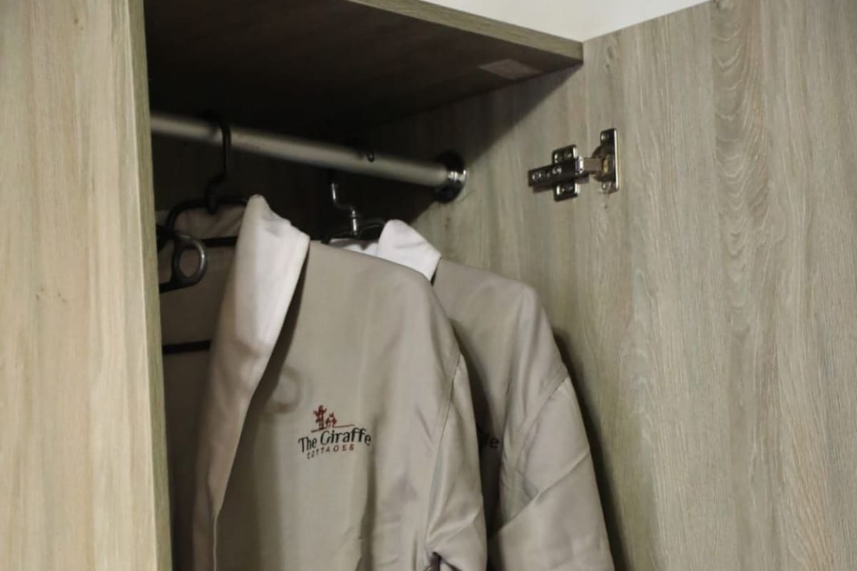 A wooden wardrobe with a hanging garment labeled 'The Giraffe Contadoes.'