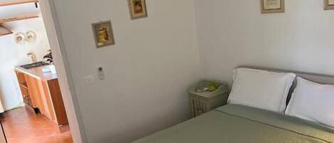 A bedroom with a bed, a nightstand, and a chandelier.