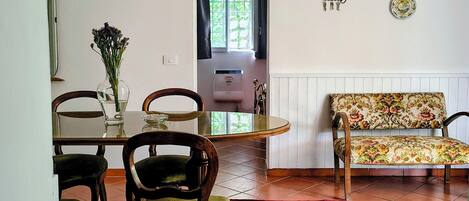 Un comedor con una araña, un sofá floral y una alfombra estampada.