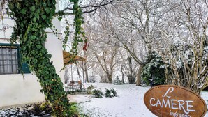 A snow-covered outdoor area with a sign reading "L CAMERE ingresso". - Levante Camere (Calderara di Reno)