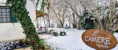 A snow-covered outdoor area with a sign reading "L CAMERE ingresso".