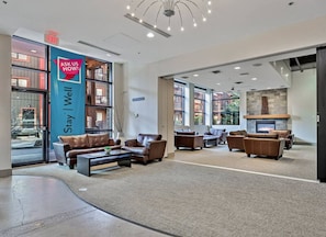 A spacious lobby with leather sofas, a fireplace, and large windows offering views of the outside. - Enjoy The Bow Valley & Give Back to Local Causes (Canmore)