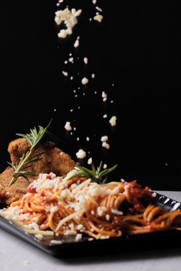 A plate of spaghetti with meatballs and a sprig of rosemary. - Triple A Hotel (Riyadh)