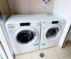 Two Candy Smartwash front-loading washing machines in a tiled room. - Oceanview Gateway 
Beautiful 2Bed/2Bath Apartment (Caniço)