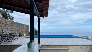 A poolside area with steps leading to a pool, lounge chairs, and a stone wall. - Suite 3 -
Private Veranda with Ocean view (Gaula)