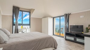 A modern hotel room with a bed, a desk, a TV, and a balcony with a view. - Suite 7 -
Private veranda with ocean view (Gaula)