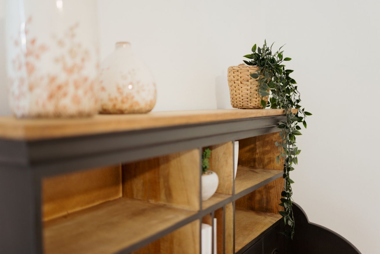 A shelf with a woven basket and a potted plant.