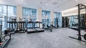 Et moderne fitnesscenter med løbebånd, spinningcykler og styrketræningsudstyr.