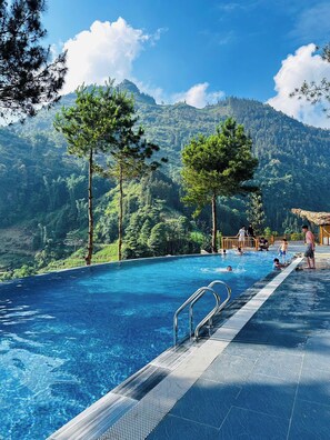 A swimming pool with a view of mountains, surrounded by trees. - Co De Chai Herbal Retreat Bac Ha (Bac Ha)