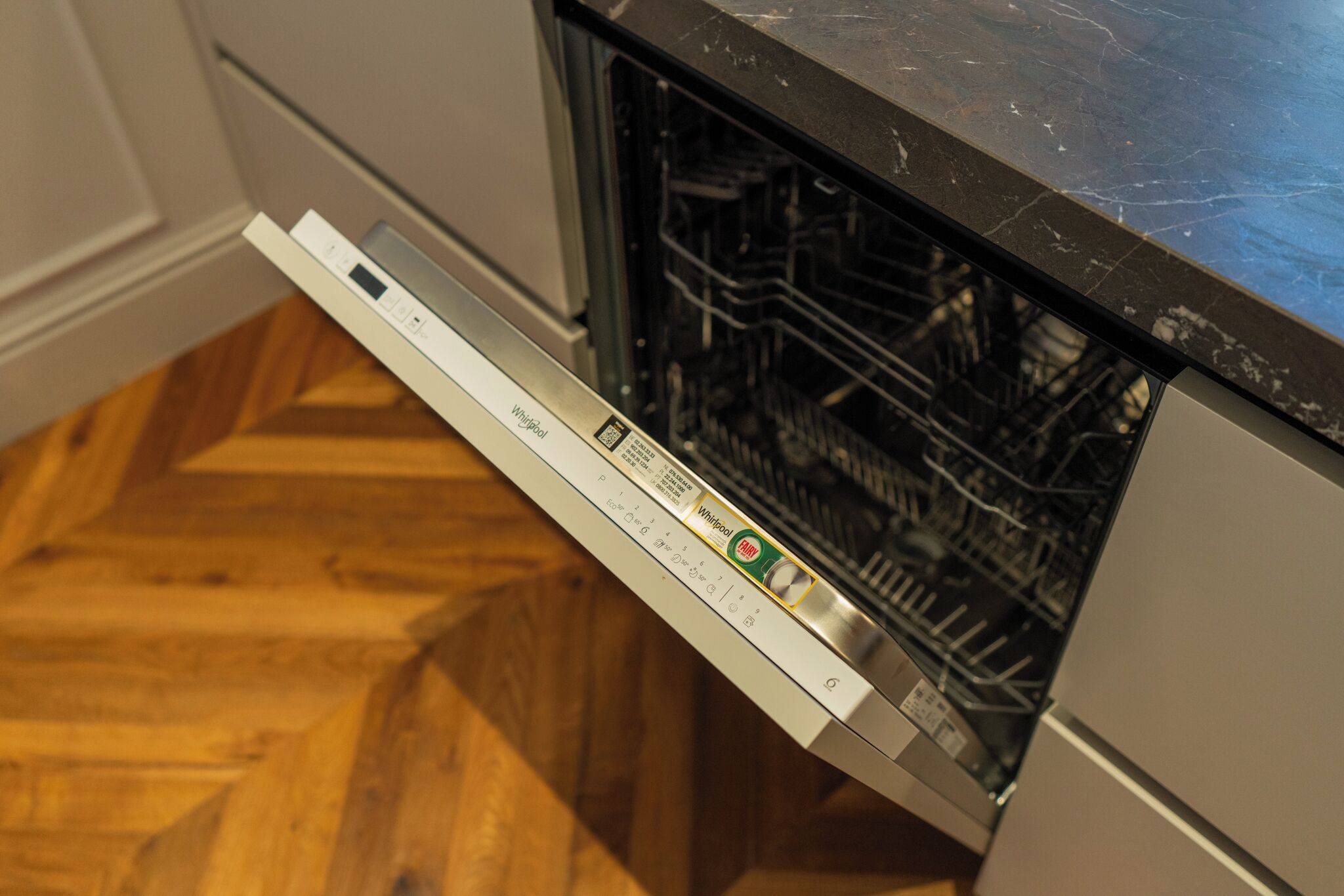 A dishwasher in a kitchen with a wooden floor.