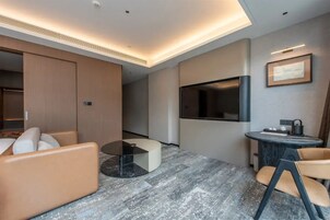 Habitación triple de lujo, vistas a la ciudad | Zona de estar