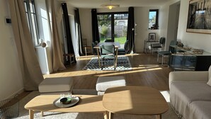 Ein großzügiger Wohnbereich mit Sofa, Couchtisch und Esstisch.