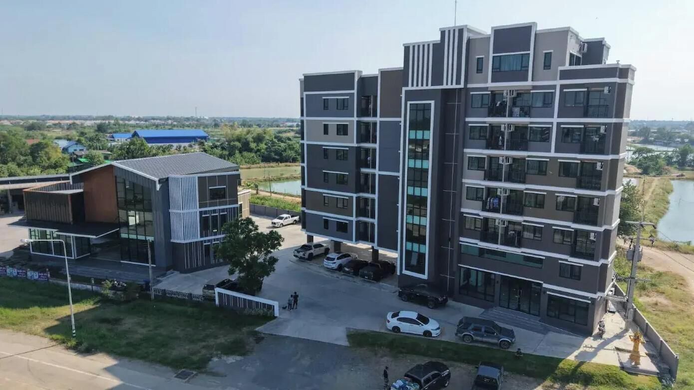 A multi-story building with a modern architectural design, featuring balconies and large windows.