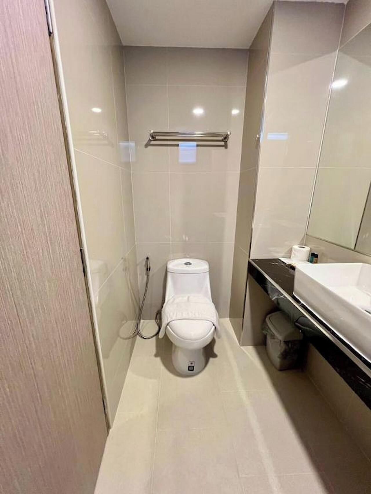 A small, modern bathroom with a toilet, bidet, and sink.
