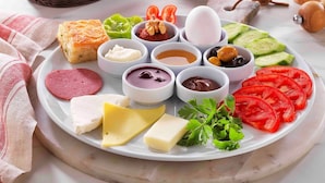 Une planche de charcuterie avec divers fromages, viandes et accompagnements.