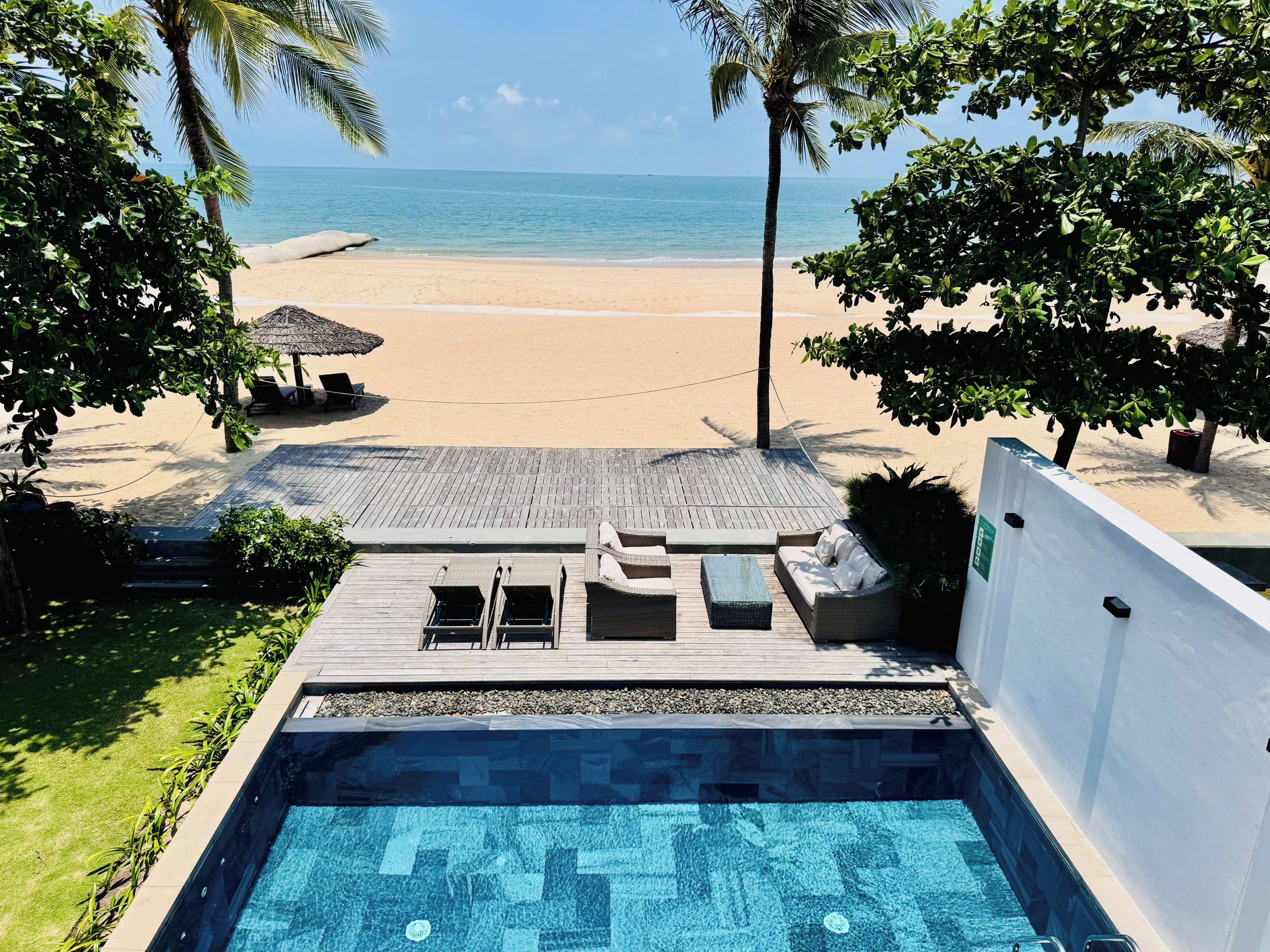 A pool area with a view of a beach and ocean.