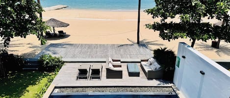 A pool area with a view of a beach and ocean.