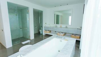 A modern bathroom with a large bathtub, a glass-enclosed shower, and a vanity with a large mirror.