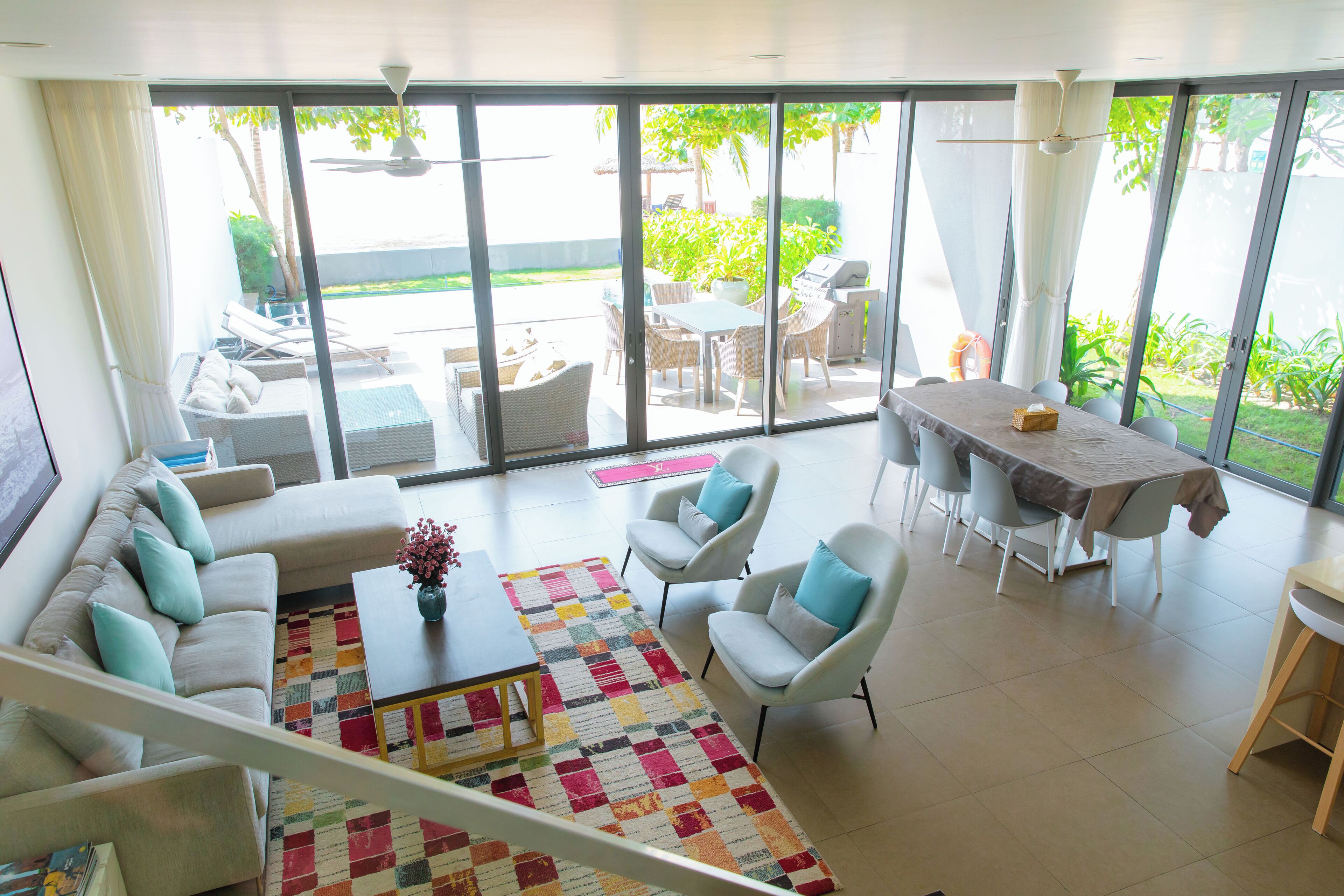 Amplia sala de estar con sofá, sillas, una mesa baja y una mesa de comedor.