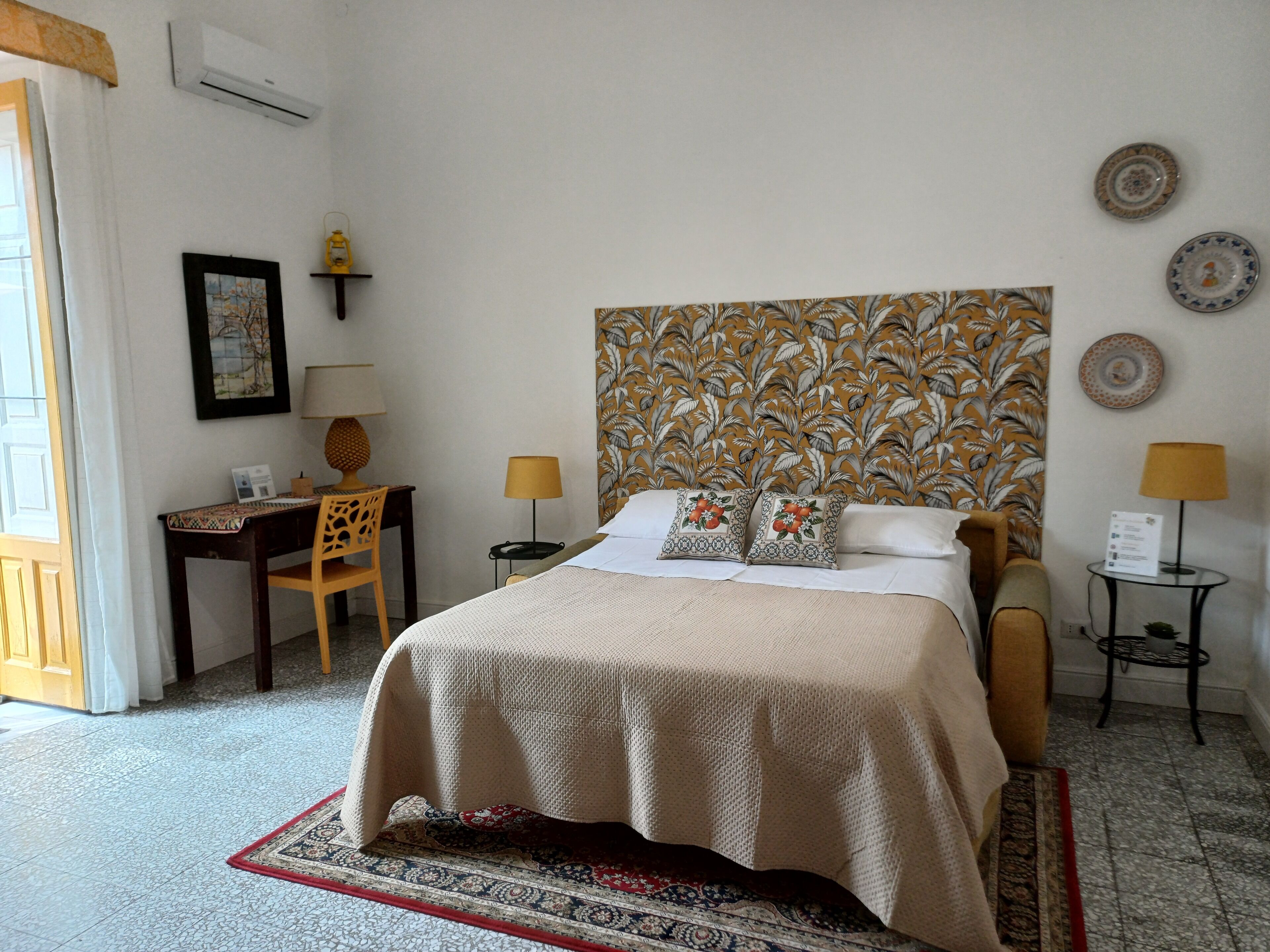 Una habitación de hotel con cama, escritorio, silla y una mesita.