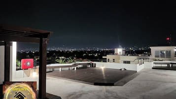 Terraza en la azotea con vistas a la ciudad de noche.