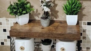 A bathroom with a white toilet, a white sink, and a mirror. There is a towel rack above the sink and a shower curtain rod above the mirror. - Simpson's Little Gem 1 (Kingston)