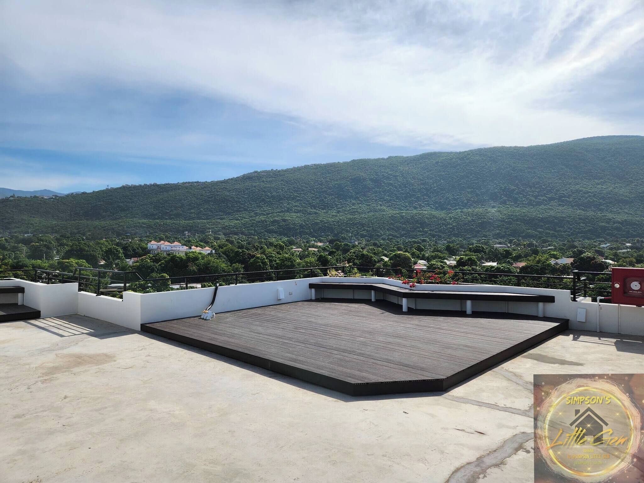 A rooftop terrace with a view of a mountainous landscape.