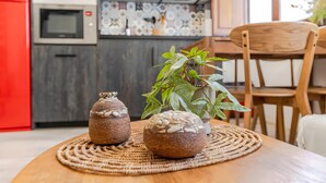 Eine Küche mit Mikrowelle, einer dekorativen Spritzschutzwand und einem Essbereich mit Holztisch und Stühlen.