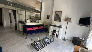 Ein Wohnzimmer mit Sofa, Couchtisch, Fernseher und Kamin.