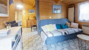A cozy cabin room with a bed, a desk, and a chair. - Chalet 213 on the edge of a forest (La Teste De Buch)