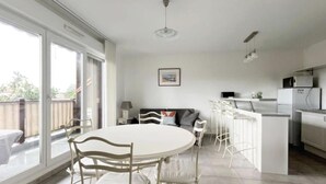 A modern kitchen with a dining area, large windows, and a view of the outdoors. - (P) T2 2 steps from the Bassin (Gujan-Mestras)