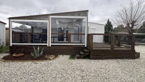 Una casa móvil pequeña de un solo piso con un porche cubierto.