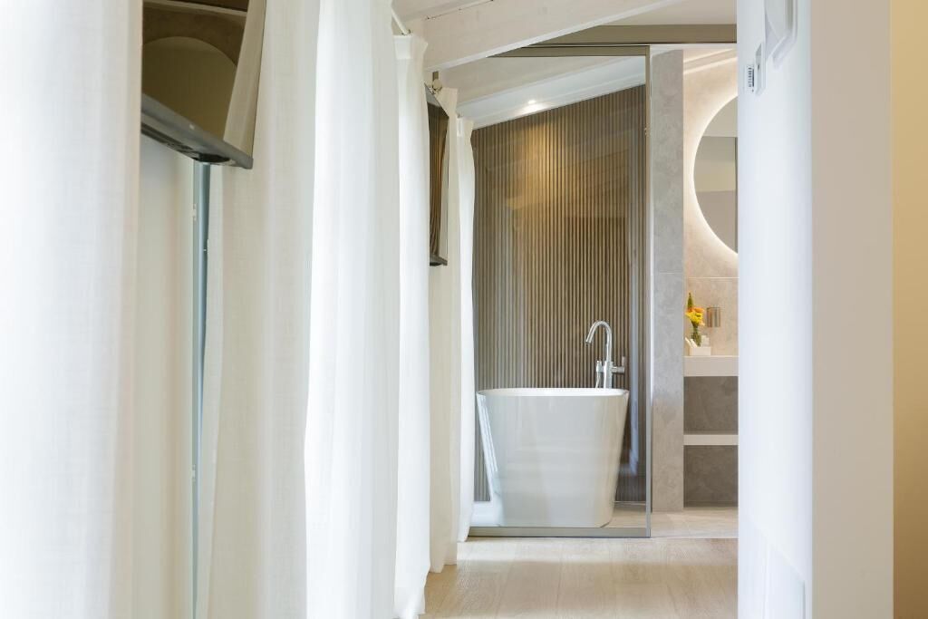 Une salle de bain moderne avec une baignoire sur pieds, une douche à parois de verre et un espace lavabo bien visible.
