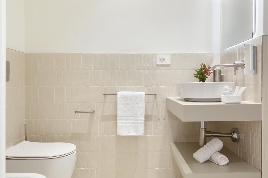 Ein modernes Badezimmer mit Toilette, Waschbecken und Duschbereich.