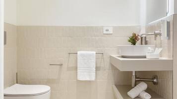 Ein modernes Badezimmer mit Toilette, Waschbecken und Duschbereich.